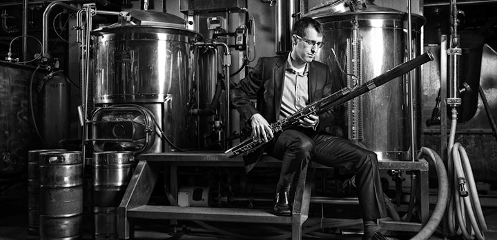 CSO musician Chris Sales holding his bassoon at a brewery 