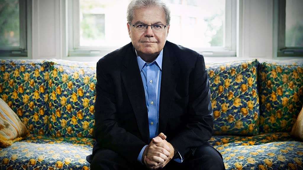 Headshot of pianist Emanuel Ax on a bright couch