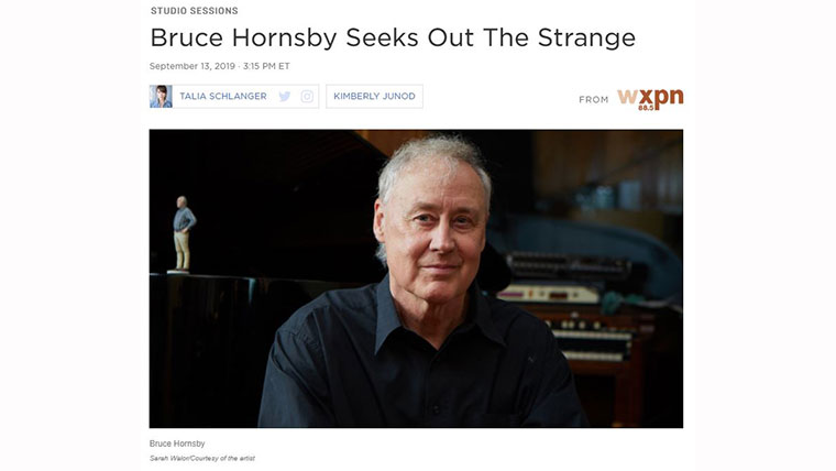 Bruce Hornsby sitting in front of a piano